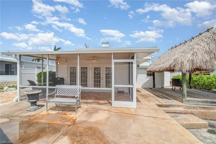 Rear view of property with french doors, a patio, a sunroom, a deck, and a ceiling fan