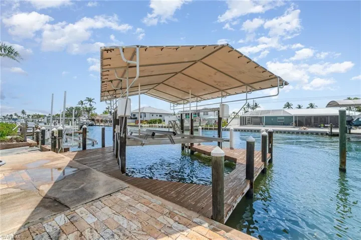 Dock area featuring boat lift and a water view