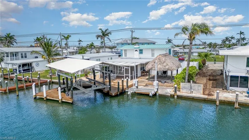 Dock area featuring boat lift, a water view, and a residential view