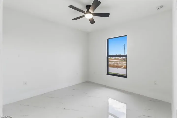Spare room with marble finish flooring and ceiling fan