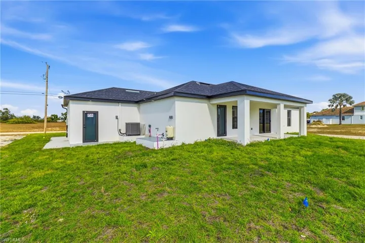 Back of property featuring a patio area, stucco siding, and a yard