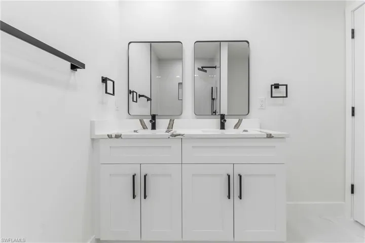 Full bath with double vanity and a shower