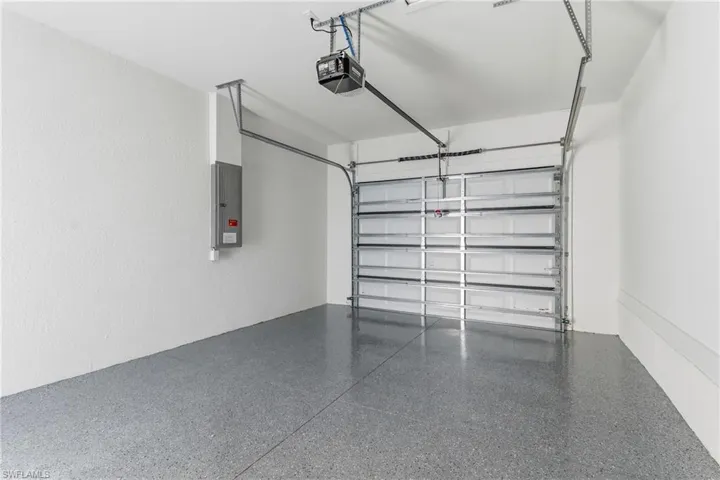 Garage featuring electric panel and a garage door opener