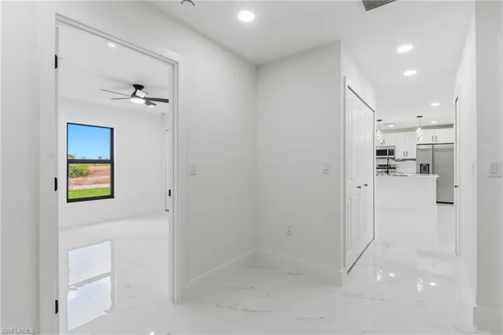 Hall with recessed lighting and light marble finish floors