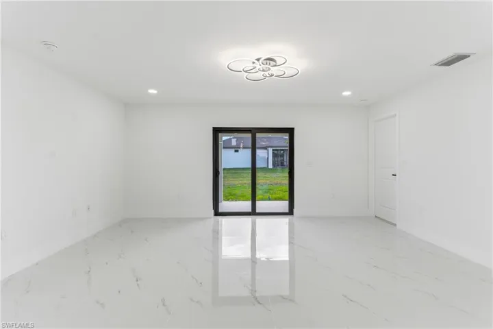 Empty room with light marble finish flooring and recessed lighting