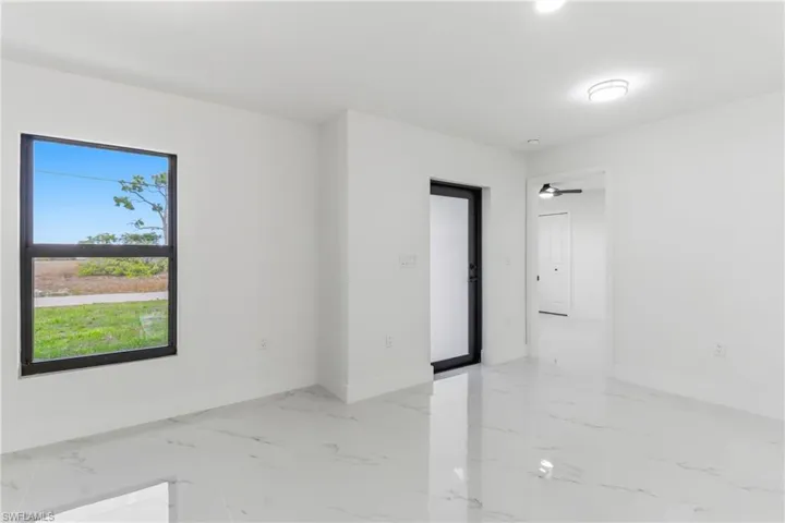 Spare room featuring light marble finish flooring and ceiling fan