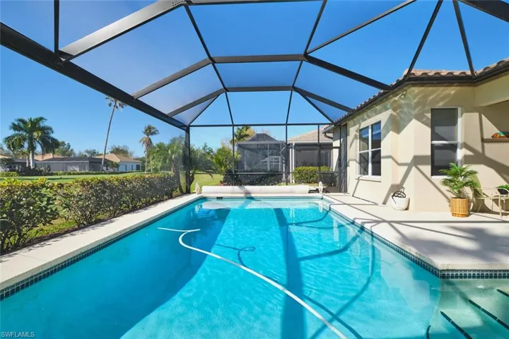 Swimming pool featuring a sunroom, a lanai, and a patio area