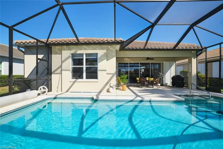 Outdoor pool featuring a sunroom, glass enclosure, a patio area, and outdoor dining space