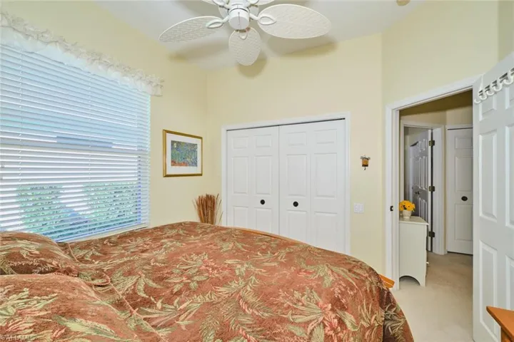 Bedroom with light colored carpet, a closet, and ceiling fan