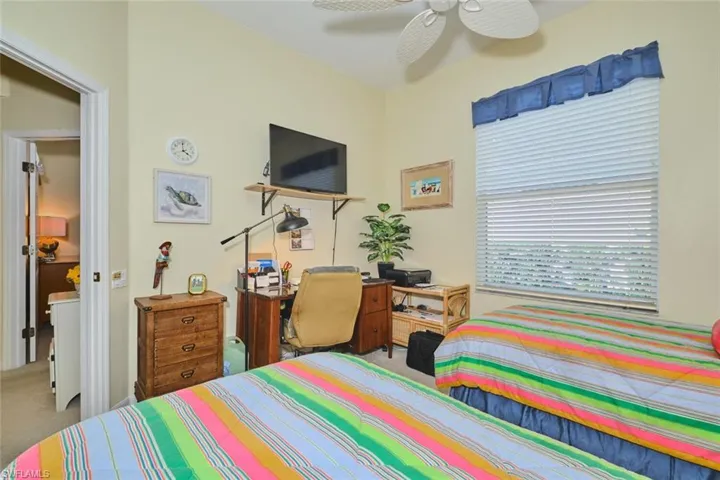 Bedroom with light colored carpet, a ceiling fan, and a closet
