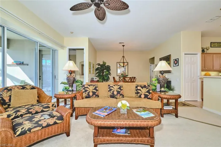 Carpeted living room featuring ceiling fan