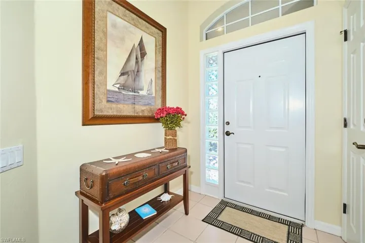 Foyer entrance featuring light tile patterned floors and baseboards