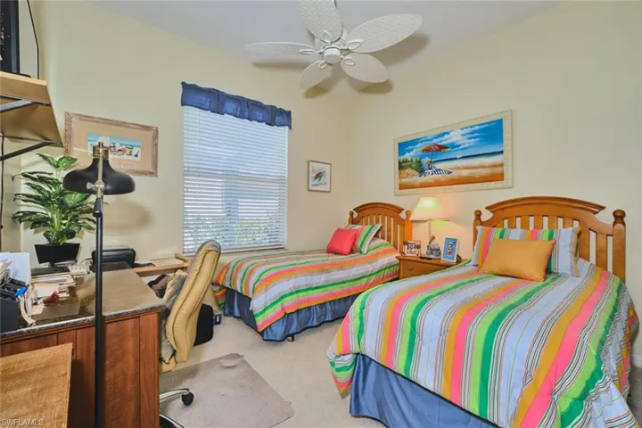 Carpeted bedroom featuring a ceiling fan