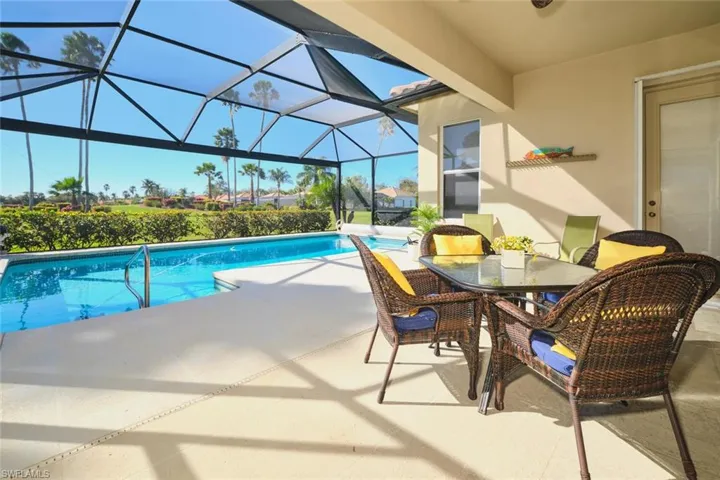 Outdoor pool featuring a sunroom, outdoor dining space, a patio, and glass enclosure