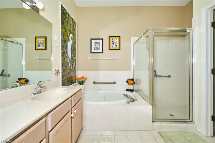 Full bathroom featuring vanity, a shower stall, light tile patterned floors, and a garden tub