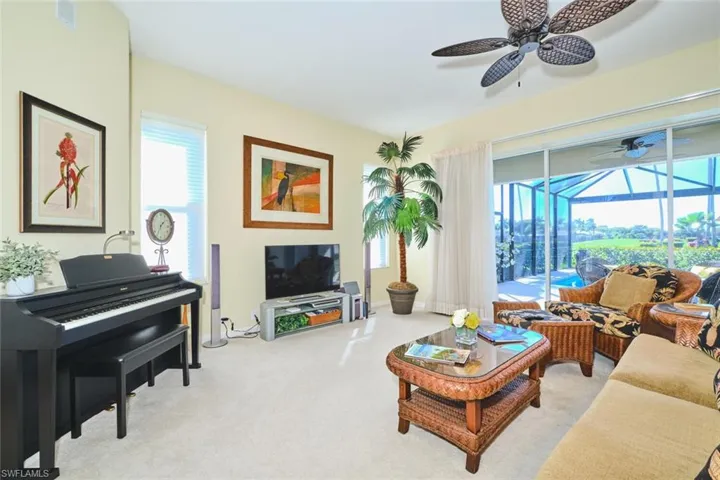 Living area featuring a sunroom, light carpet, and ceiling fan