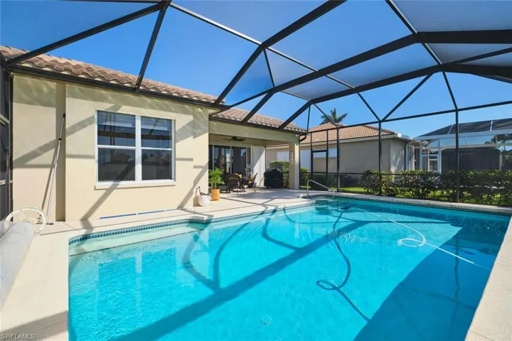 Outdoor pool featuring a patio area, glass enclosure, and a sunroom
