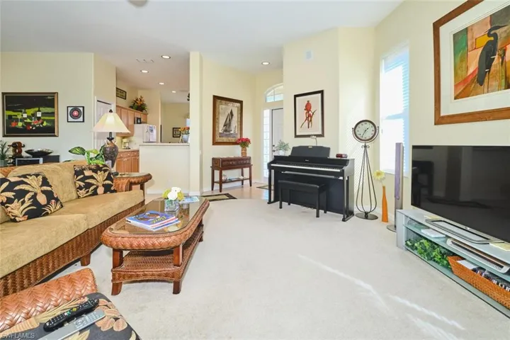 Living area featuring light colored carpet, healthy amount of natural light, and recessed lighting