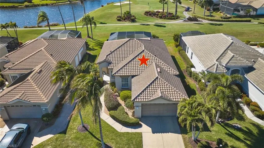 Aerial view of residential area featuring a nearby body of water and a local golf course