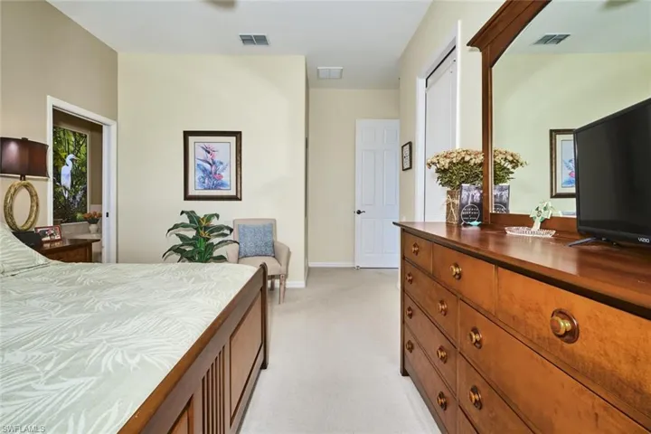 Bedroom with light colored carpet and ensuite bath