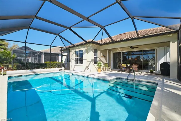 Outdoor pool with a sunroom, a patio area, and glass enclosure