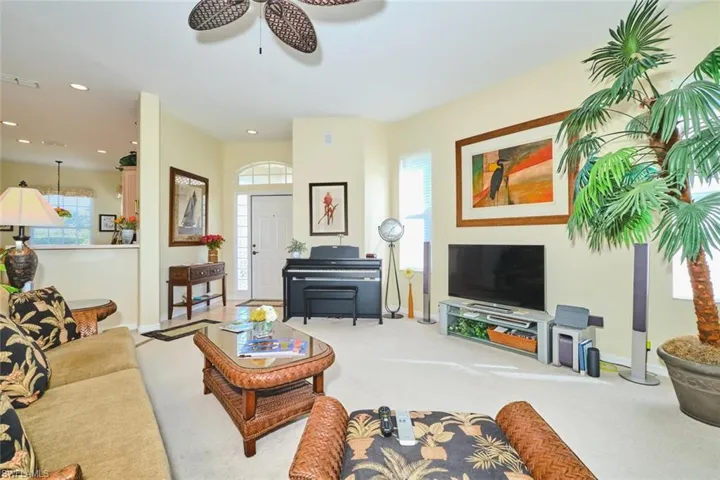 Carpeted living room featuring healthy amount of natural light, recessed lighting, and a ceiling fan