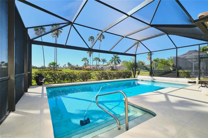Outdoor pool with a sunroom, a patio area, and glass enclosure