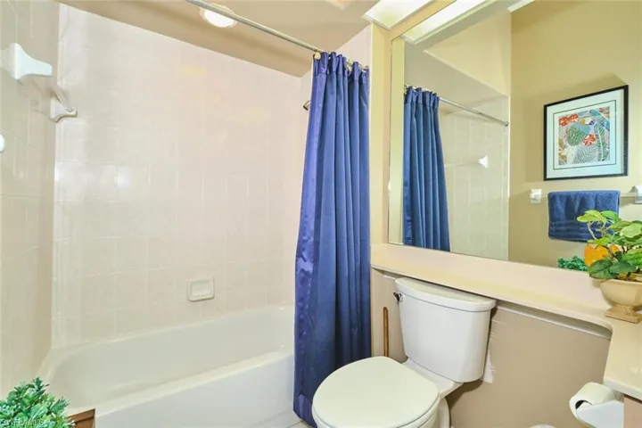 Bathroom with toilet and shower / bath combo with shower curtain