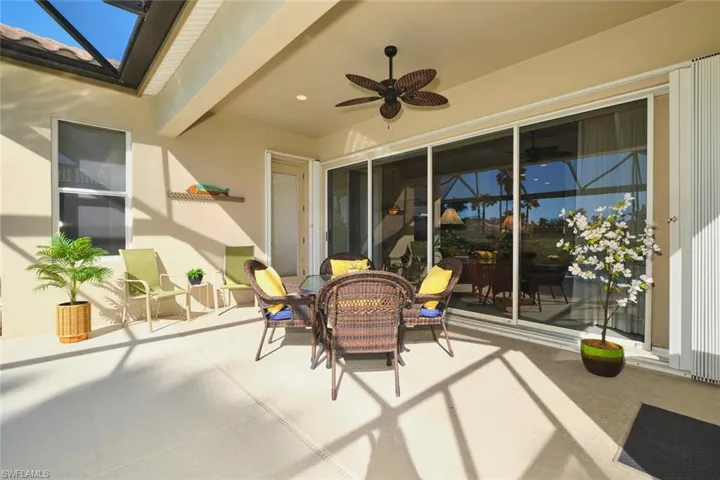 View of patio / terrace featuring a ceiling fan, outdoor dining space, and glass enclosure