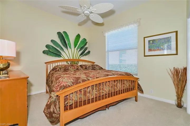 Bedroom with ceiling fan and light carpet