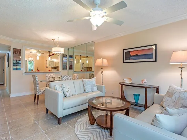 Great room featuring tile floors, ceiling fan, and crown molding