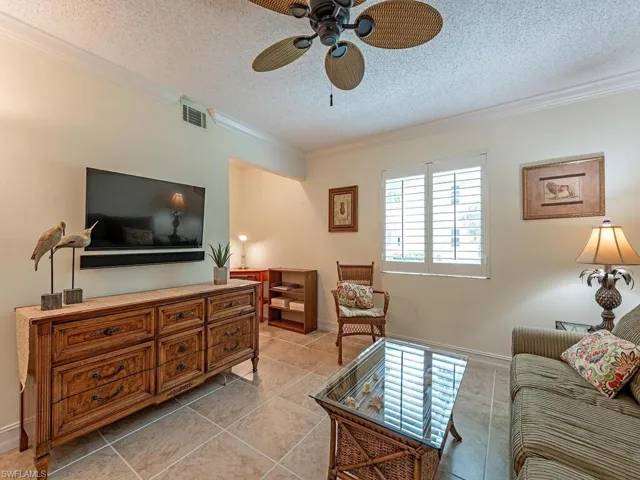 3rd bedroom set up as a den, featuring tile floor, and crown molding