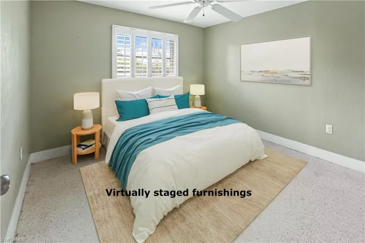 Neutral-toned room featuring a window with white plantation shutters, light green wall paint, and white baseboards