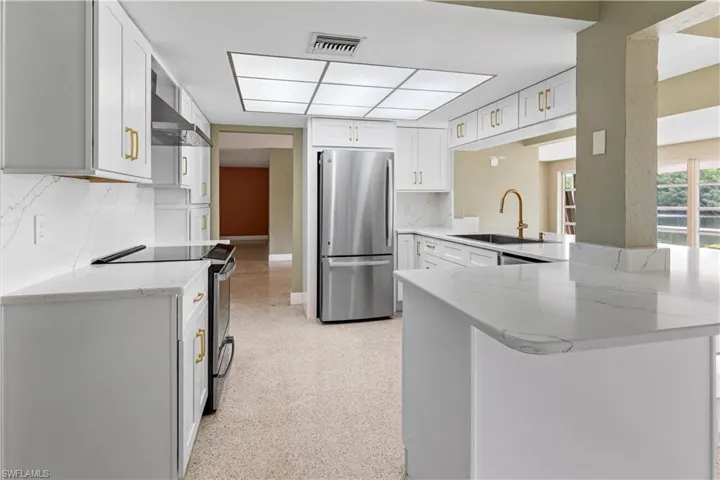 Modern kitchen featuring white cabinetry, stainless steel appliances,