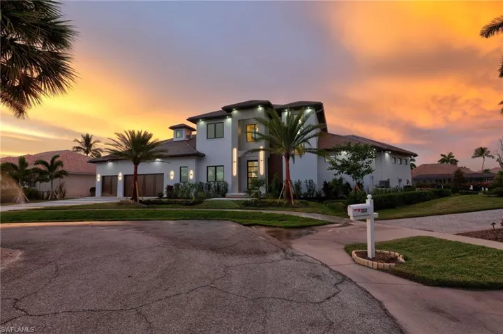 View of front of house featuring concrete driveway, stucco siding, a garage, and a front lawn