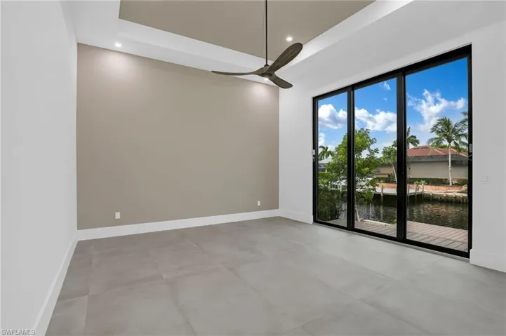 Spare room with a water view, ceiling fan, recessed lighting, and concrete flooring