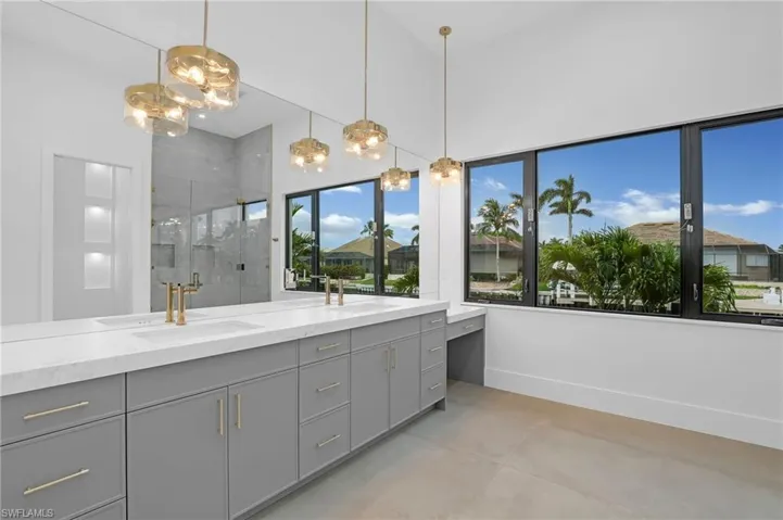 Full bath with a stall shower, double vanity, and concrete flooring