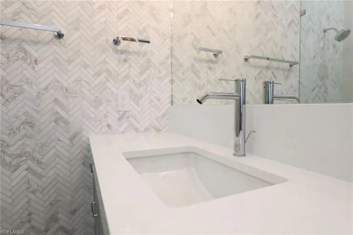 Bathroom view of vanity and tiled shower