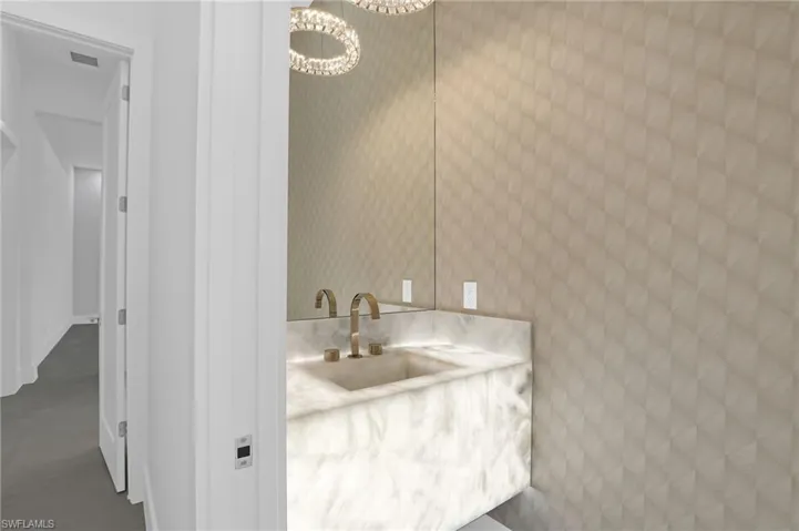 Bathroom with a chandelier, vanity, and concrete flooring