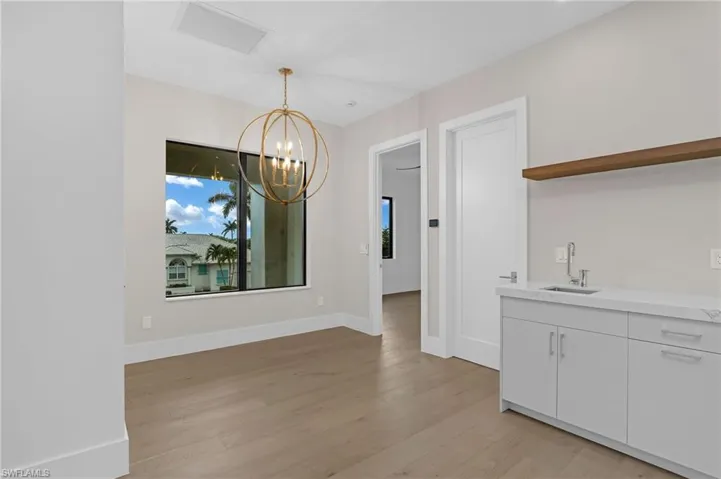 Unfurnished dining area with a chandelier and light wood-style floors