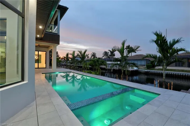 View of swimming pool featuring a pool with connected hot tub, a patio area, and a water view