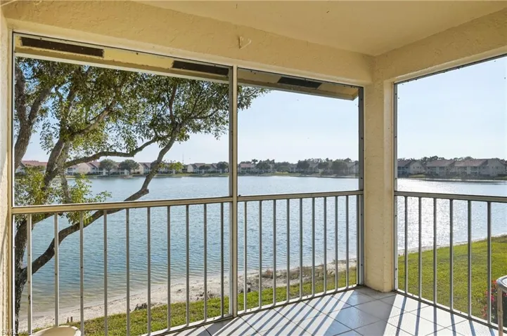 Unfurnished sunroom featuring a water view and a residential view