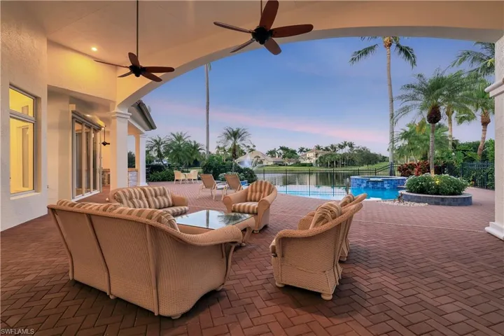 Patio terrace at dusk with a patio, a ceiling fan, and a pool with connected hot tub