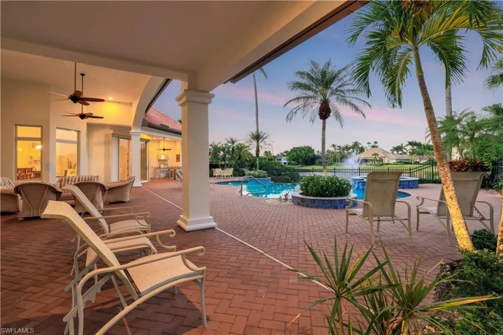 View of patio featuring ceiling fan and a pool with connected hot tub