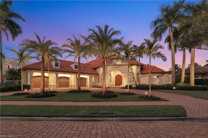 Mediterranean home with curved driveway, stucco siding, and a front lawn