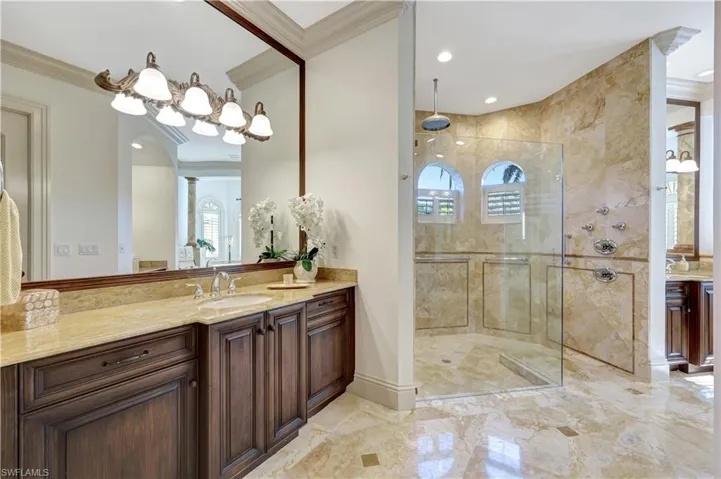 Full bath with vanity, crown molding, a stall shower, light marble finish floors, and recessed lighting