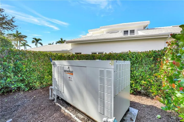 Exterior view of stucco siding and a tile roof with 48 watt whole house generator with two, 1,000 gallon propane underground tanks.