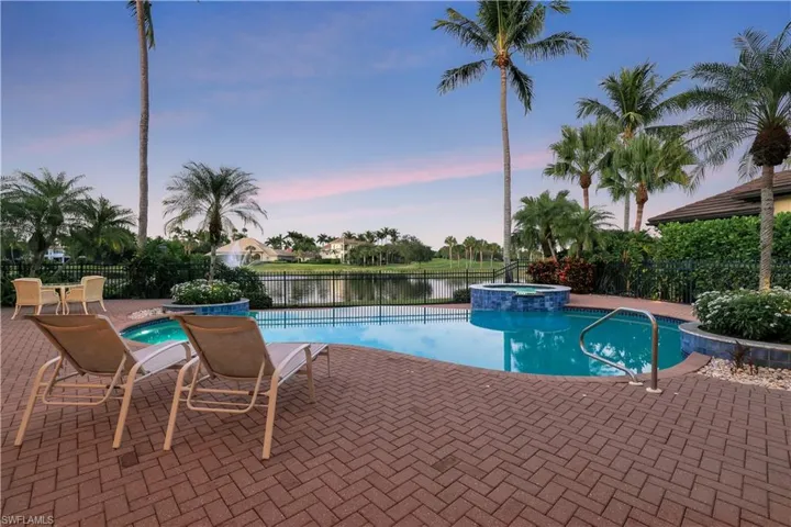 View of pool with a patio area, a pool with connected hot tub, and a water view