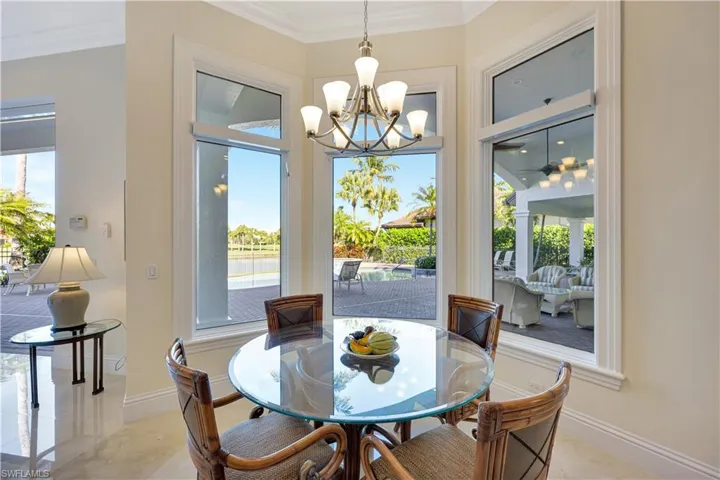 Dining space with crown molding, a chandelier, and a water view
