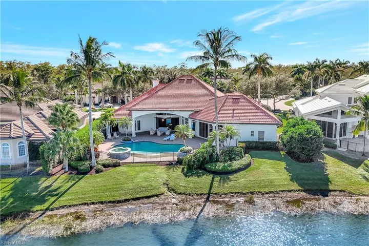 Back of house featuring a patio, a tile roof, stucco siding, a pool with connected hot tub, and a chimney